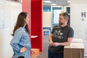 Jeff and Julie discussing lessons learned in the office hallway