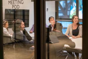 Four leaders sitting around a high table, with coffees, taking a moment to connect